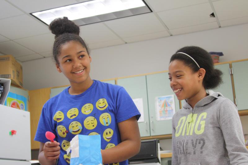 Harmoney Mahoney, left, and Mikayla Black measure pancake ingredients during a CARE cooking class. BY MATTHEW BERNAT